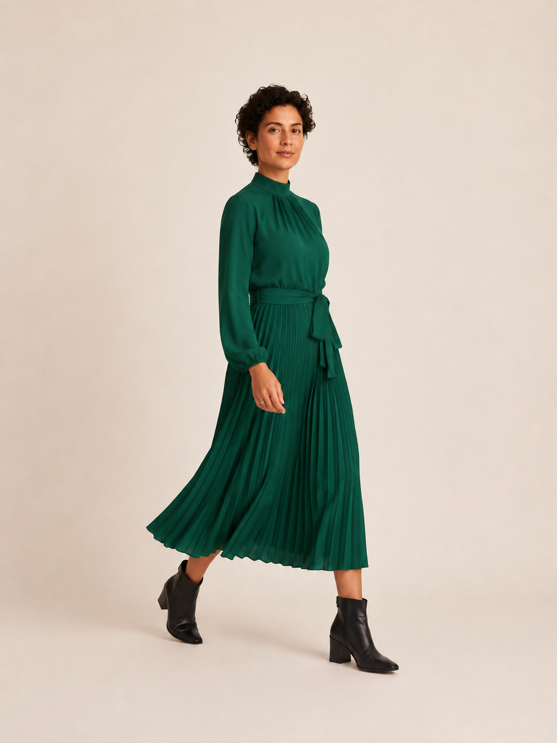 Green belted pleated midi dress, side view in movement